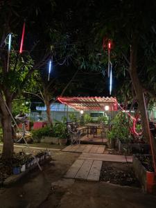 eine Terrasse in der Nacht mit einem Picknicktisch und Lichtern in der Unterkunft Baan Suan Resort2345 in Ban Nong Waeng
