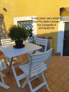 een tafel en stoelen met een potplant op een patio bij A due passi dal castello in San Pio delle Camere