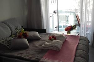 un grande letto con cuscini e fiori di Port Vauban appartement F3 refait à neuf a Antibes