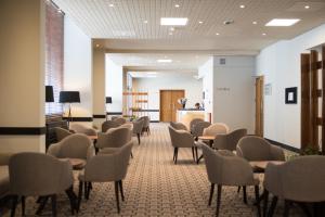 a waiting room with chairs and tables in a building at Lancaster Hall Hotel in London +29 photos