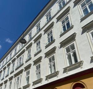 - un bâtiment blanc avec des fenêtres sur le côté dans l'établissement Stilvolles Apartment in zentraler Lage, à Vienne