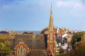 a church with a tall steeple in a city at Sunnycroft in Deal