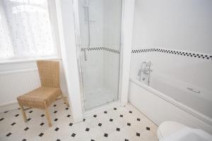 a bathroom with a shower and a chair and a toilet at Sunnycroft in Deal