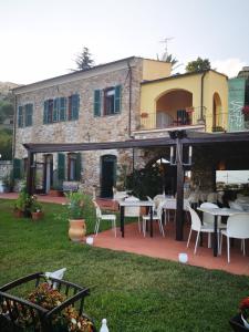 een patio met tafels en stoelen voor een gebouw bij Villa Govi in Diano Castello