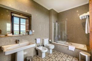a bathroom with a sink and a toilet and a tub at Hotel Llenaire in Port de Pollensa