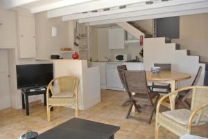 a living room with a table and chairs and a kitchen at En Avignon in Les Angles Gard