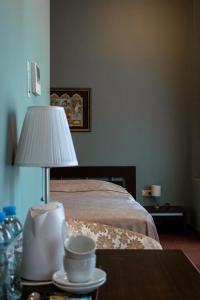 um quarto com uma cama e uma mesa com um candeeiro em Boutique Hotel Modern em Yaroslavl