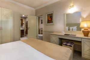 1 dormitorio con cama y tocador con espejo en Polat Thermal Hotel, en Pamukkale