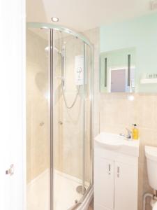 een badkamer met een douche en een wastafel bij The Ravenswood B&B in Torquay