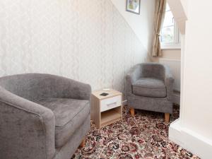 a living room with a couch and a chair at The Ravenswood B&B in Torquay