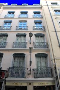 un edificio blanco con balcones en un lateral en Hotel de Bretagne en Lyon