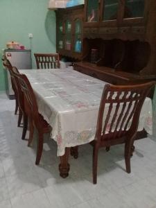 a table with four chairs and a table with a table cloth at AMIMAS HOMESTAY in Kampong Bagan Samak