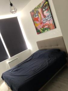 Ce lit se trouve dans une chambre dotée d'une affiche murale. dans l'établissement L’APPART23, à Châlons-en-Champagne