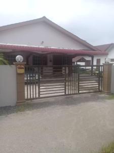 a house with a gate in front of it at AMIMAS HOMESTAY in Kampong Telok