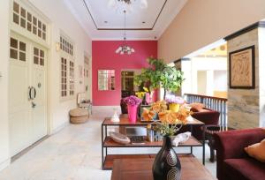 una sala de estar con paredes rosas y una mesa con flores. en Le Krasak Boutique Hotel, en Yogyakarta