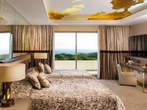 a bedroom with a bed with a view of the ocean at Rixos Premium Belek - The Land of Legends Access in Belek