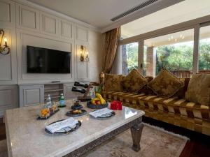 a living room with a couch and a table at Rixos Premium Belek - The Land of Legends Access in Belek
