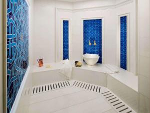a white bathroom with blue tiles on the walls at Rixos Premium Belek - The Land of Legends Access in Belek