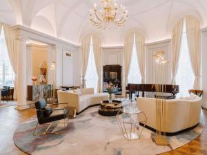 a living room with a couch and a piano at Raffles Europejski Warsaw in Warsaw
