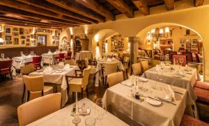 a restaurant with tables and chairs with white tablecloths at Residence Traube in Bressanone