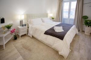 a bedroom with a large white bed and a window at Duomo Luxury Suite Catania in Catania