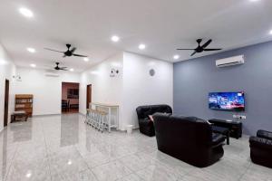 a living room with black chairs and a tv at Stay Inn Sikamat (Seremban Homestay) in Seremban