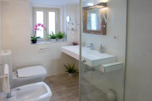 a bathroom with a sink and a toilet and a mirror at Duomo Luxury Suite Catania in Catania