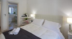 a bedroom with a large white bed with towels on it at Duomo Luxury Suite Catania in Catania
