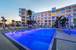 a large swimming pool in front of a building at Limanaki Beach Hotel & Suites in Ayia Napa