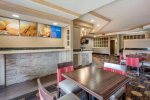 a restaurant with a wooden table and chairs at Comfort Suites Marion North in Marion