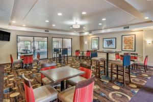 a restaurant with tables and chairs in a room at Comfort Suites in Marion