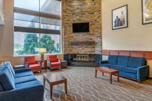 a waiting room with chairs and a fireplace at Comfort Inn in Lansing
