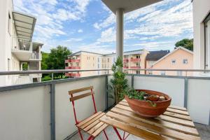 a wooden bench sitting on a balcony with a plant at DAREBELL Apartment Gratkorn Top 3 in Gratkorn