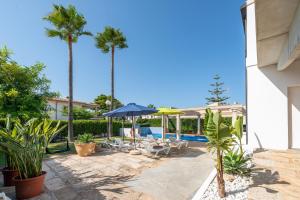 un patio con palmeras y una piscina en Estrel, en Can Picafort