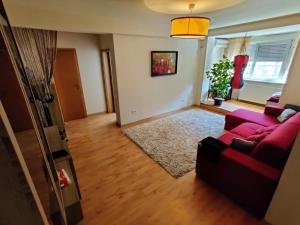 a living room with a red couch and a rug at Lucky Home Timisoara 1 in Timişoara