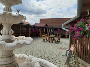 a fountain in the courtyard of a building with flowers at Restaurant and Pension Stenly in Spišský Štvrtok