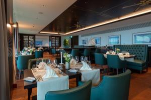 a dining room with tables and green chairs at Bad Horn - Hotel & Spa in Horn