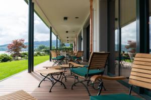 een veranda met stoelen, tafels en ramen bij Bad Horn - Hotel & Spa in Horn