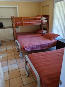 a bed room with two beds and a desk at Shearwater Cottages in Port Sorell