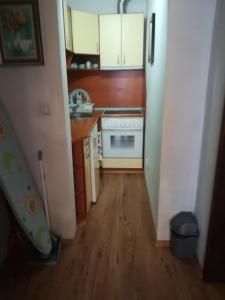 a small kitchen with wooden floors and white cabinets at Guest House Stenli in Primorsko
