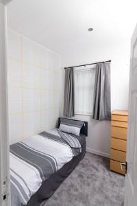 um pequeno quarto com uma cama e uma janela em Entire House - 2 Bedroom - 3 Bed - Free wifi - TV em Clayton le Moors