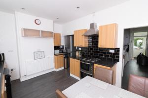 a kitchen with wooden cabinets and a stove top oven at Entire House - 2 Bedroom - 3 Bed - Free wifi - TV in Clayton le Moors