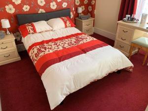 a bedroom with a large bed with red carpet at Aden House Bed And Breakfast in Mintlaw