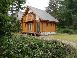 ein großes Holzhaus mit einer Terrasse in einem Hof in der Unterkunft Hakuba Powder Cottage Deep in Hakuba