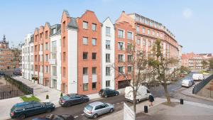 a city street with cars parked in front of buildings at Dom & House - Apartments Old Town Tartaczna in Gdańsk