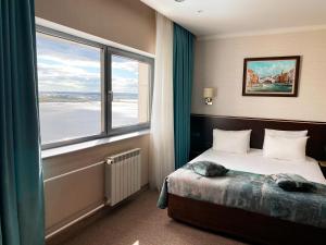 Un pat sau paturi într-o cameră la Riviera Hotel