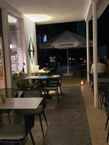 een restaurant met tafels en stoelen en een parasol bij Hotel und Pension Brunnenhof in Bad Salzuflen