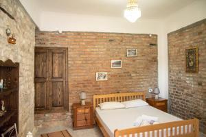 a bedroom with a brick wall and a bed at Guesthouse Belle View in Berat