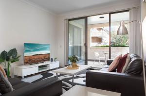 a living room with two couches and a tv at Spacious Two-Bedroom Apartment near Hospital DUPLICATE in Sydney