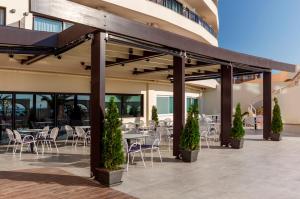 a patio with tables and chairs in a building at Cactus Hotel in Rhodes Town